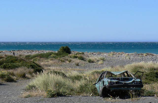 une épave de voiture avec la mer dans le fond