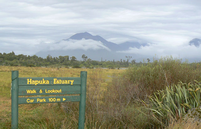 panneau Hapuka Estuary à 100 m. Montagnes nuageuses dans le fond