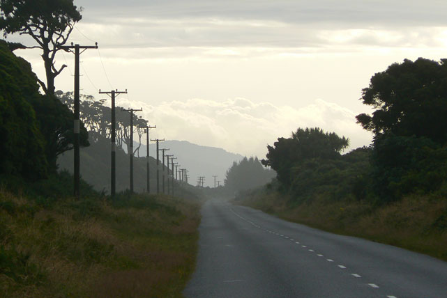 zoom sur le bout de la route, poteaux electriques alignés, fond lumineux