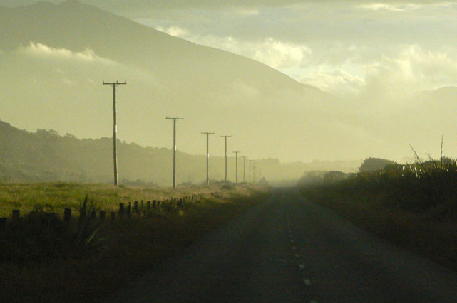 route brumeuse et déserte avec lumière du soleil couchant